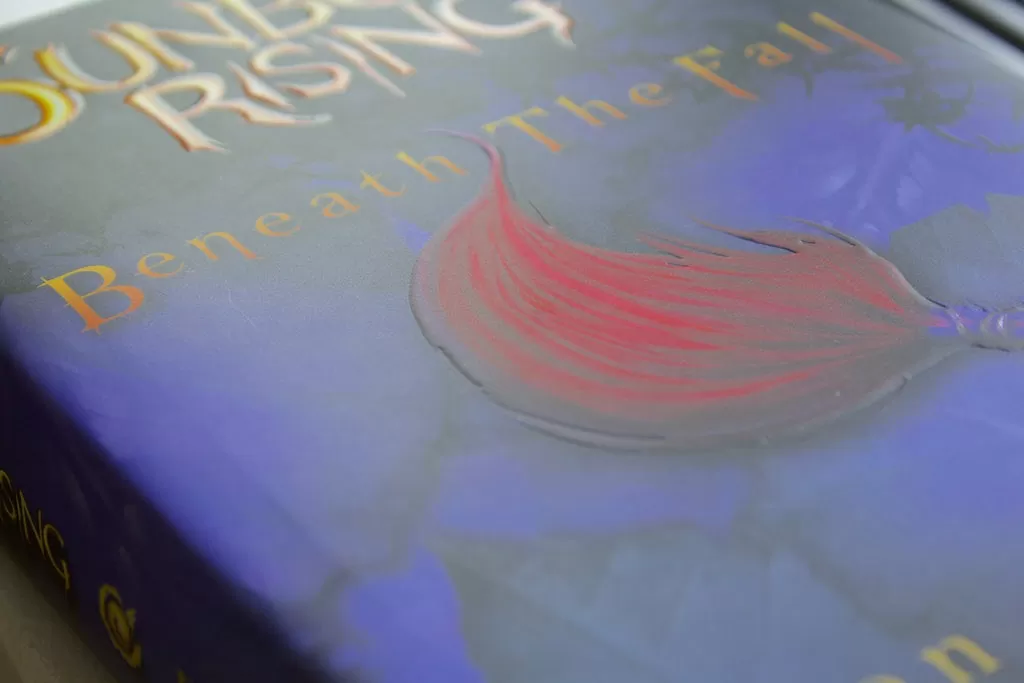 Sunborn Rising used specialty features on their gorgeous matte cover to parallel the magic of their epic fantasy world. Embossing gives the main design element depth, while spot UV pulls your eye across the title and colorful gems.